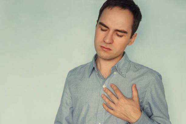 istock Young man in white t-shirt with strong heart attack, experience, feeling, emotion, worry, 1053025064