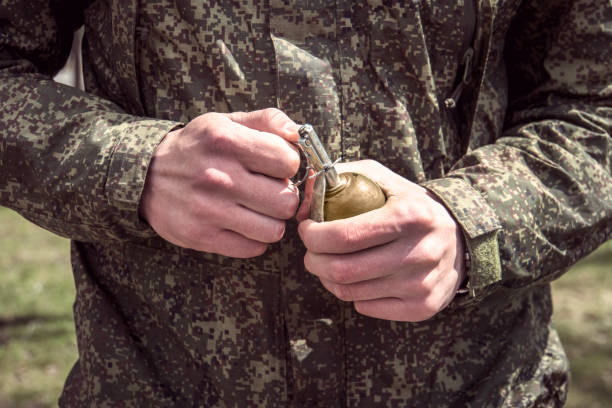 grenade, mains sur la broche. le soldat tire un chèque d’une grenade à fragmentation rgd-5. l’explosion - hand grenade explosive bomb war photos et images de collection