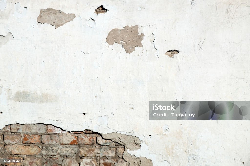 Damaged brick wall, cracked plaster. Damaged brick wall, cracked plaster. Textured background Eroded Stock Photo