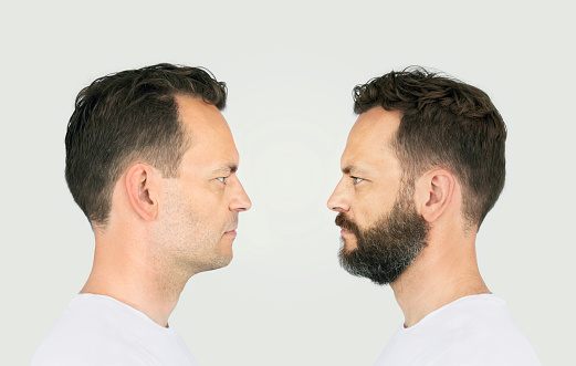 Mature males looking at each other. Male identical twins in white t-shirt are looking into each other's eyes. Face to face and looking at your self.