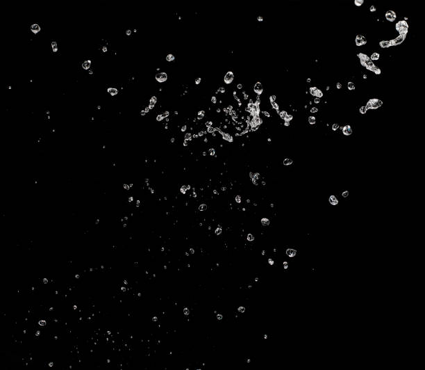 spruzzo d'acqua isolato su sfondo nero - black drop water waterdrop foto e immagini stock