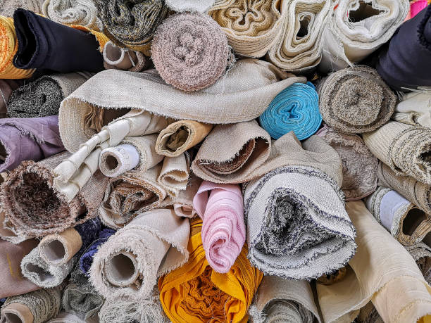 istock Rolls of multi-colored patterned textiles for sale in a Northern Thai market. 1053038006