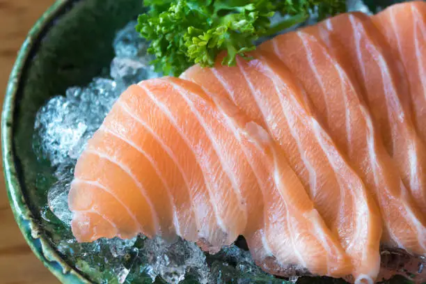 Close up of salmon, sashimi, japanese food on the ice bowl