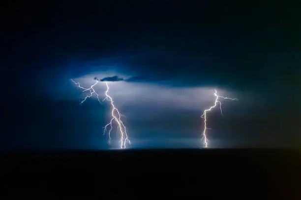 Dual bright lightning that goes into depth of black sea, with branching branches in different directions, which illuminate the southern coast of Crimea and Yalta