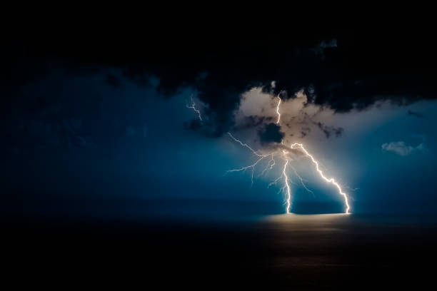istock Dual bright lightning that goes into depth of black sea, with branching branches in different directions, which illuminate the southern coast of Crimea and Yalta 1053040562