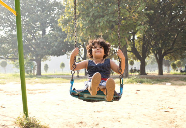 istock Little girl on swing at park 1053048820