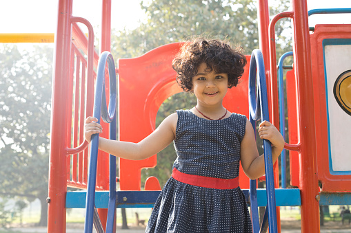 Little Indian girl standing on amusement park ride