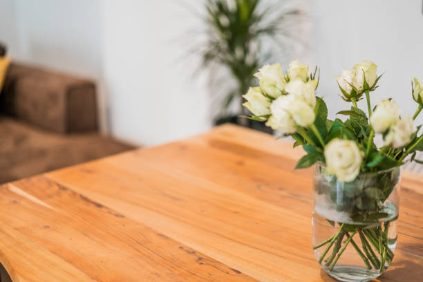 Vase with white roses on wooden table desk