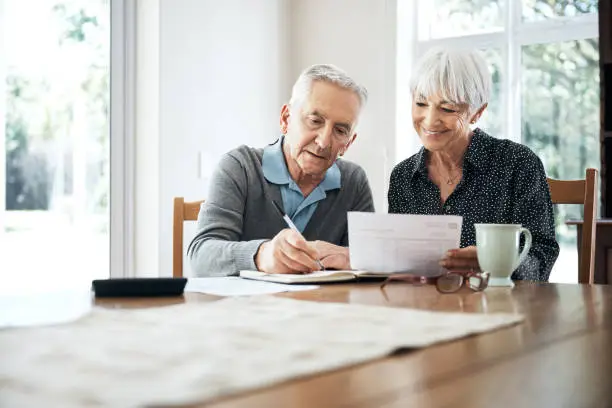 Cropped shot of a senior couple going through their finances while sitting at the dining room table