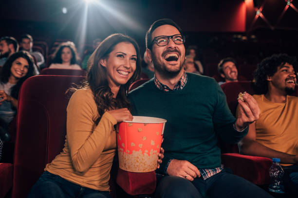 istock Laughing couple eating popcorn in cinema 1053057978