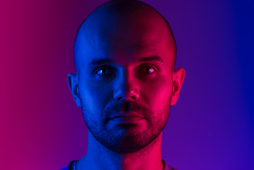 Portrait of a man. Dual tone lighting theme. Pink and blue colors