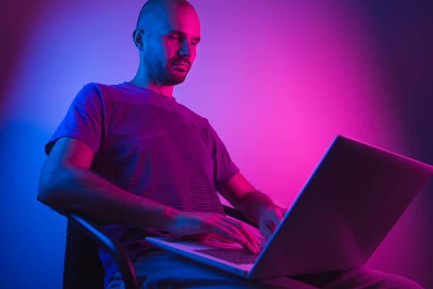 istock A man sits on a chair and uses a laptop. Dual tone lighting 1053058422