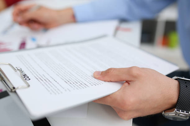 istock Female arm in suit offer contract form on clipboard pad 1053059912