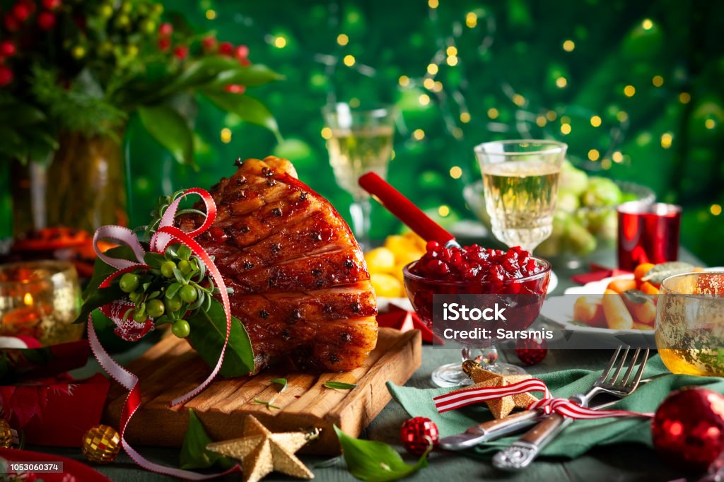 Christmas food Glazed roast ham with cloves,sparkling wine and traditional vegetables dishes for Christmas dinner. Christmas Stock Photo