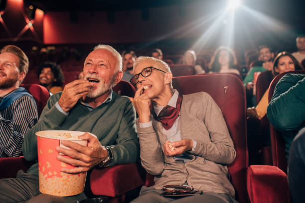 istock Old couple eating popcorn at cinema 1053060666