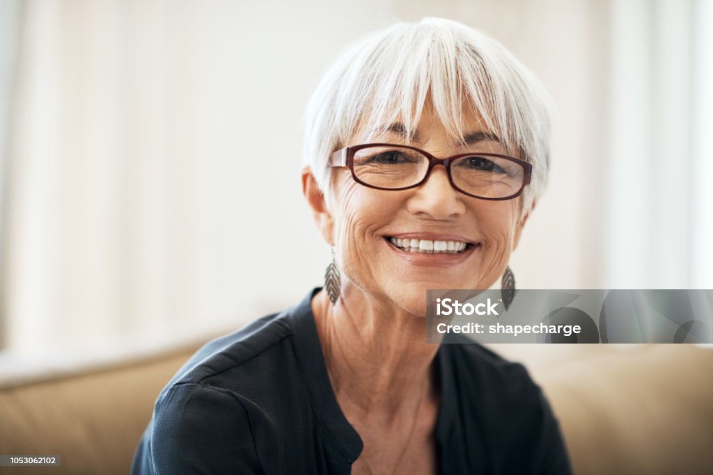 I'm absolutely loving retirement Cropped portrait of a senior woman sitting on the sofa at home 70-79 Years Stock Photo