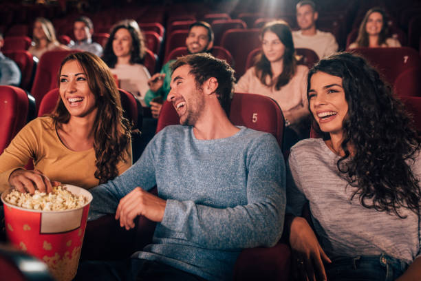istock Happy people eating popcorn at cinema 1053062572