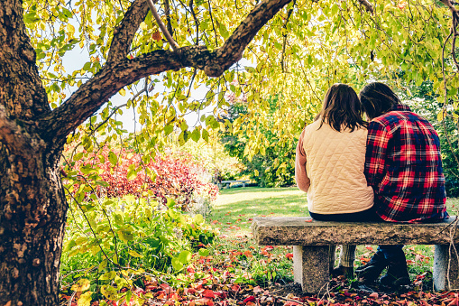 Fall, Couple, Love, Romance, Relationship - Romantic couple sitting under a cozy tree and holding each other close, enjoying the fall colors.