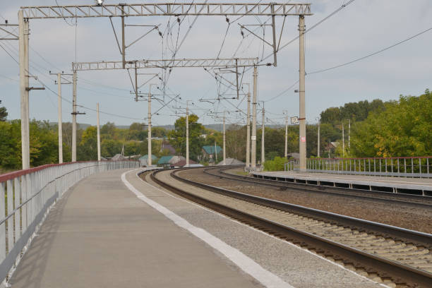 istock Two railway tracks and passenger platforms at a small Siberian station, Russia. 1053067164