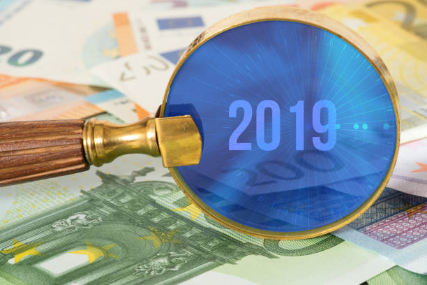 istock Euro banknotes, a magnifying glass and the year 2019 1053071148