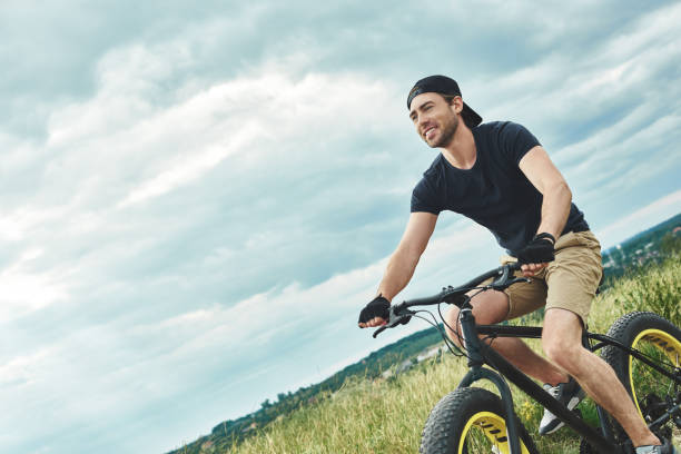 istock Handsome stylish guy cycling at the mountains. Bottom view 1053073958