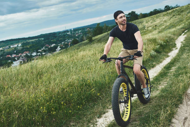 istock Handsome stylish guy cycling at the mountains 1053073974