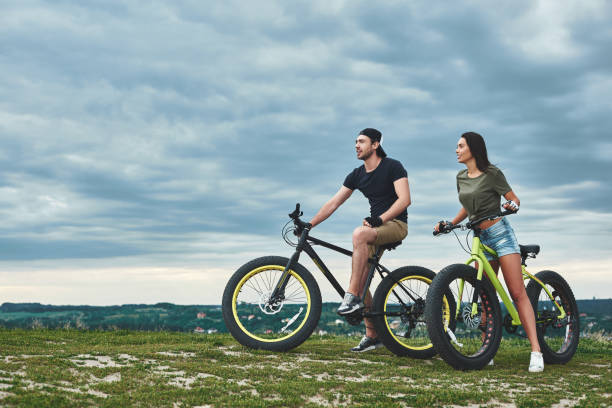 istock Afternoon sunset with mountainbike couple. Side view 1053075796