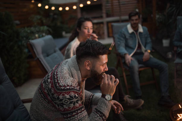 istock Millennial man eating s'mores 1053079482