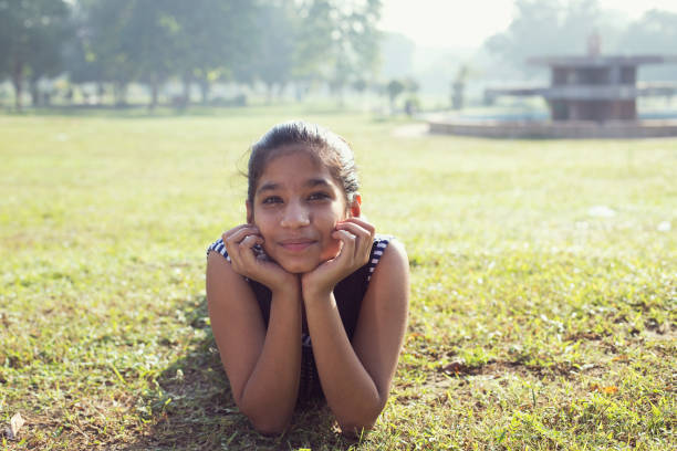 istock Teenage girl lying down on grass 1053082068