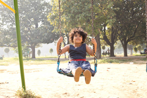 istock Little girl on swing at park 1053083840