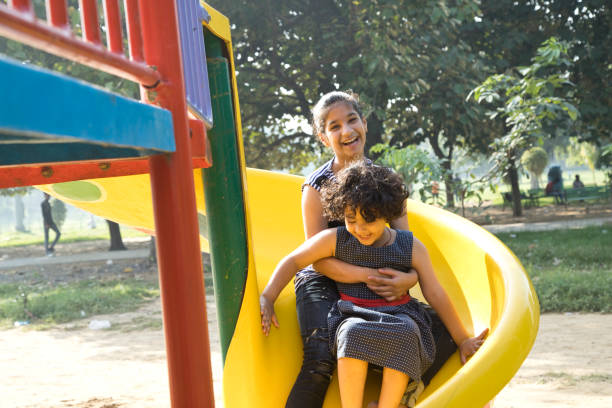 istock Girls sliding down at amusement park 1053086202