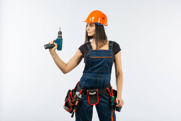 Young woman with toolbelt using driil and some power tools for her work at home. Girl working at flat remodeling. Building, repair and renovation. Young woman with toolbelt using driil and some power tools for her work at home. Girl working at flat remodeling on white background. Building, repair and renovation. woman wearing tool belt stock pictures, royalty-free photos & images