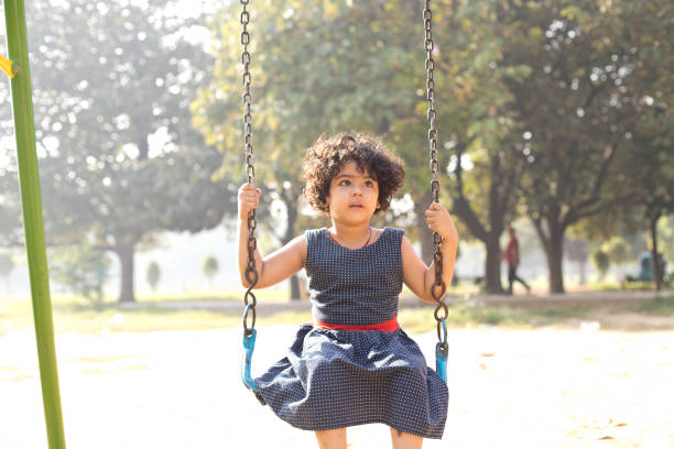 istock Little girl on swing at park 1053087028