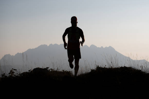 istock Mountain runner in silhouette in a suggestive landscape 1053094168