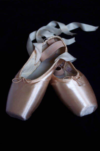 istock Pink ballet Pointe shoes with ribbons on black background 1053098708
