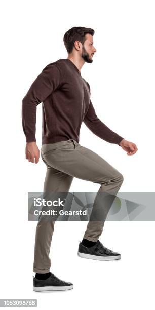 An Isolated Bearded Man In Casual Wear Steps Up With One Leg In A Side View On A White Background Stock Photo - Download Image Now