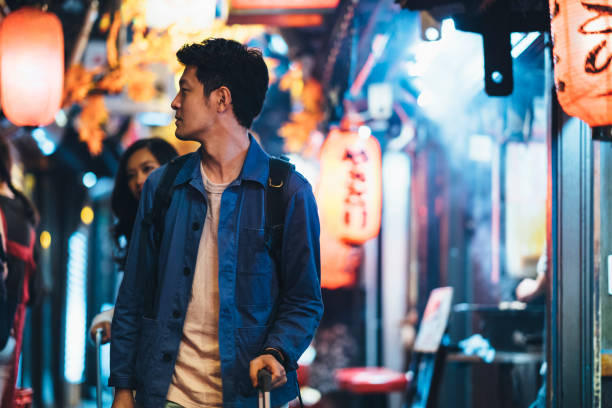 istock Asian tourists walking small alley at night 1053100480