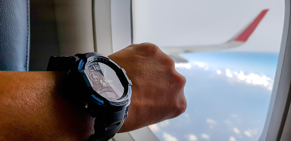 Man on the jet plane is in hurry situation so that he always stare at his watch.