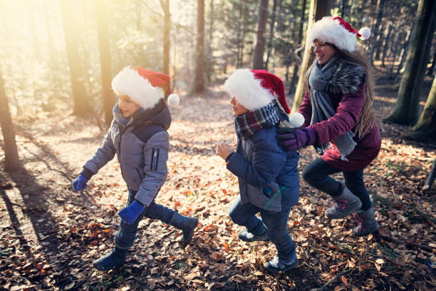 istock Kids enjoying running in snowless forest on Christmas 1053104452