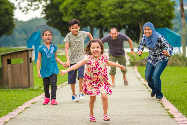 muslim family chasing after the little girl - pre adolescent child child group of people little boys imagens e fotografias de stock