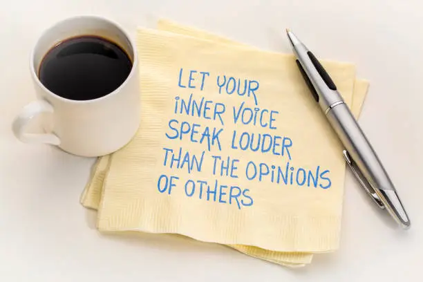 let your inner voice speak louder than the opinions of others - inspirational handwriting on a napkin with a cup of coffee