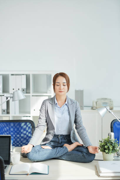 istock Businesswoman meditating at office 1053113818