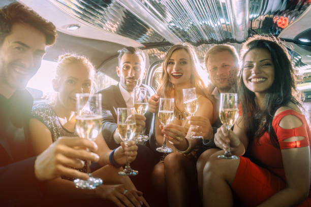 istock Group of party people in a limo drinking 1053114506