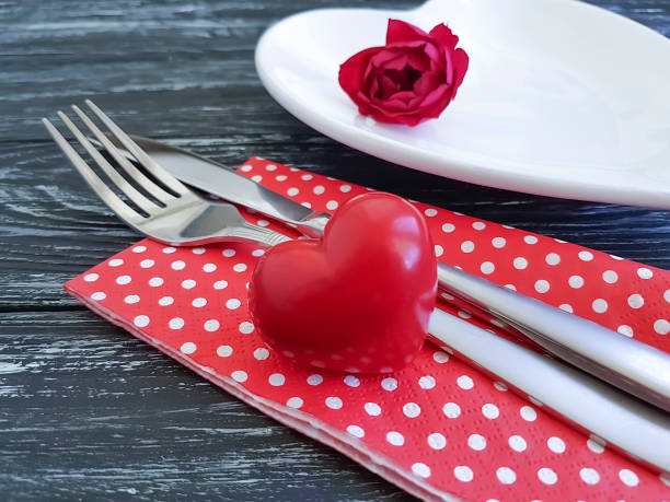 istock fork, knife, plate heart, flower rose on wooden background 1053115228