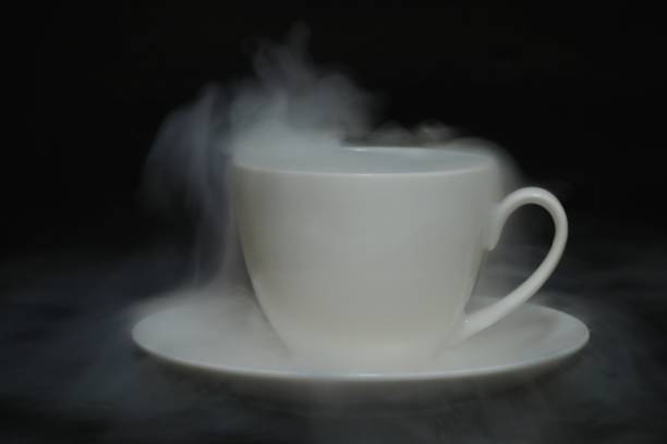 coffee cup with white fog of dry ice on black background