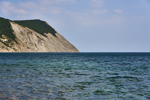 Panoramic view of the sea surface from the coast. On the left is a rock. Black Sea, Supseh, Anapa, Krasnodar region, Russia.