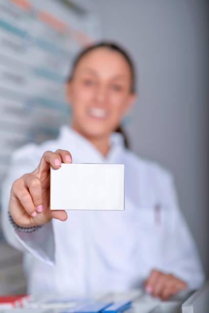 istock pharmacist showing white blank medicine box with pharmacy store shelves background 1053133738