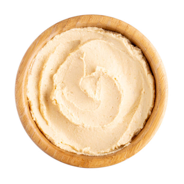 Classic chickpea hummus in wooden bowl isolated on white. Top view.