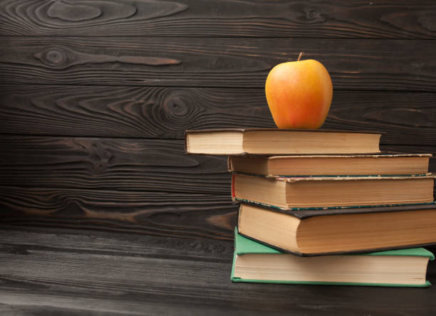 istock Stack of old books, wooden background. 1053144820