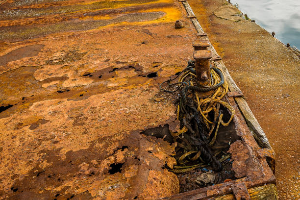 istock Two bollards of brown rusty iron with old ropes at the quay 1053144826